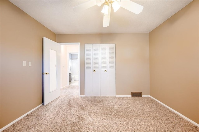 unfurnished bedroom featuring a closet, carpet, a ceiling fan, and baseboards