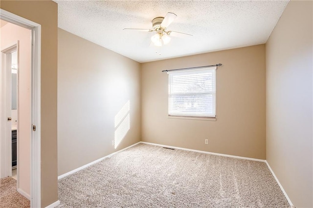 carpeted spare room featuring ceiling fan, baseboards, and a textured ceiling