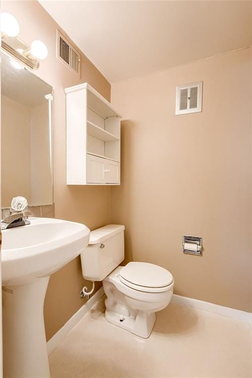 bathroom featuring baseboards, visible vents, and toilet