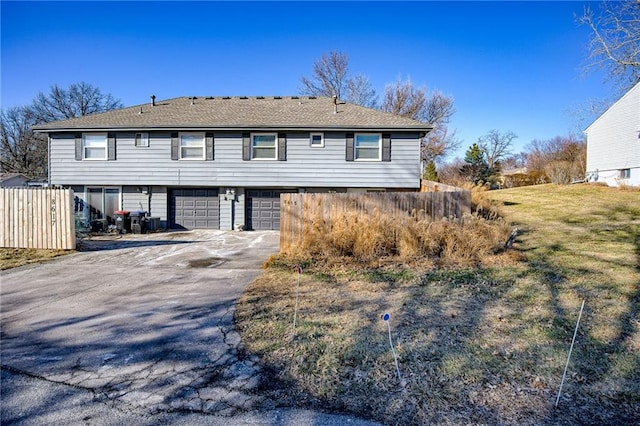 view of front facade featuring fence, driveway, and an attached garage