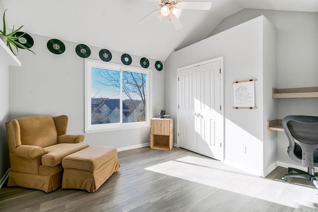 sitting room with vaulted ceiling, wood finished floors, a ceiling fan, and baseboards