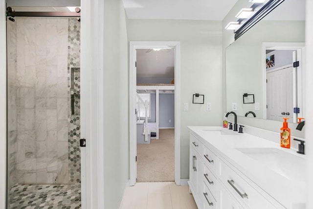 bathroom with double vanity, a shower stall, and a sink