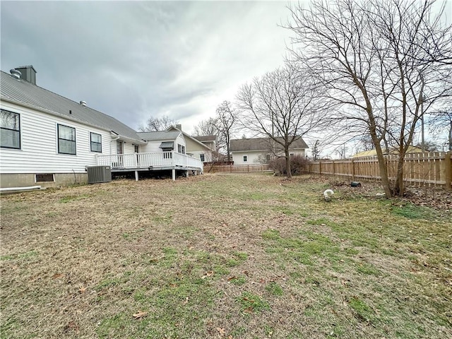 view of yard with fence, central AC unit, and a wooden deck