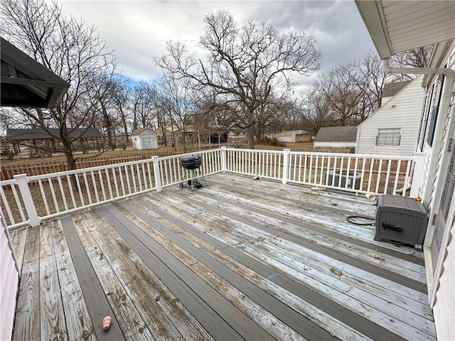 wooden terrace with an outdoor structure and a shed