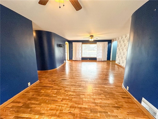 unfurnished living room with light wood-type flooring, baseboards, visible vents, and a ceiling fan