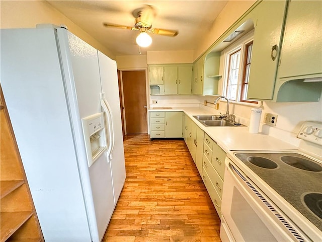 kitchen with white appliances, a sink, light countertops, open shelves, and green cabinetry