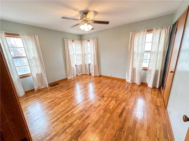 unfurnished bedroom featuring visible vents, a ceiling fan, light wood-style flooring, and baseboards