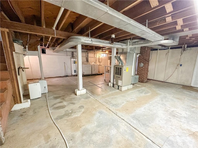 unfinished basement featuring water heater, independent washer and dryer, and heating unit