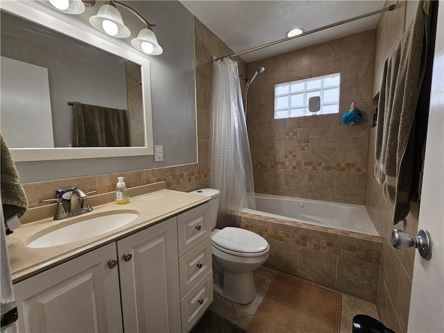 bathroom featuring toilet, tiled shower / bath combo, tile patterned flooring, vanity, and tile walls