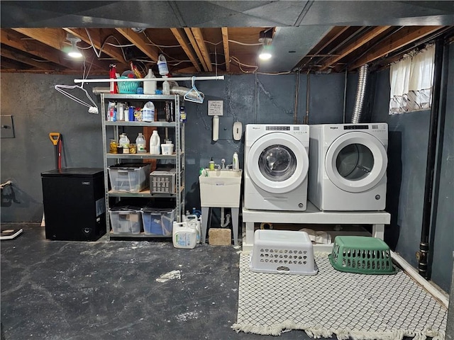 washroom featuring a sink, laundry area, and washing machine and dryer