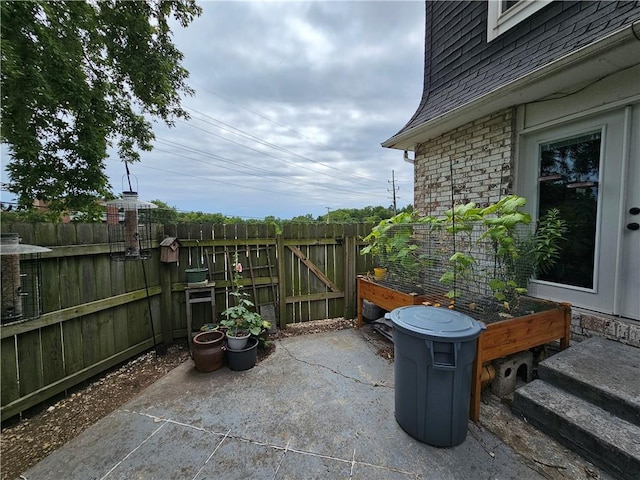 view of patio featuring fence and a gate