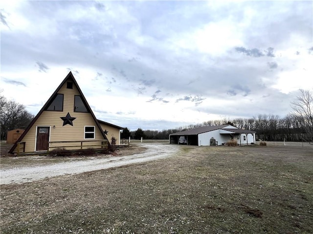 view of property exterior with dirt driveway and an outdoor structure