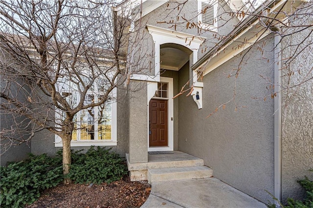 view of exterior entry featuring stucco siding