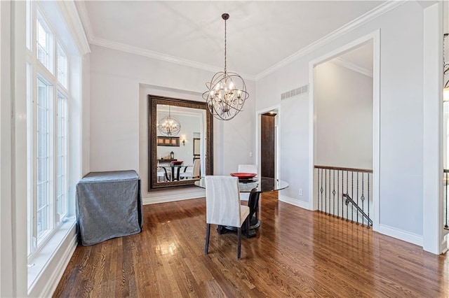 dining room featuring an inviting chandelier, visible vents, wood finished floors, and ornamental molding