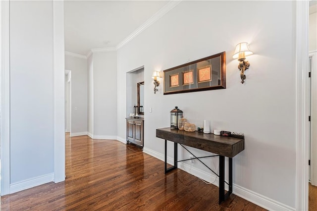 hall with ornamental molding, wood finished floors, and baseboards