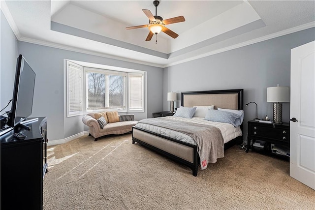 bedroom featuring baseboards, a tray ceiling, ornamental molding, and light colored carpet