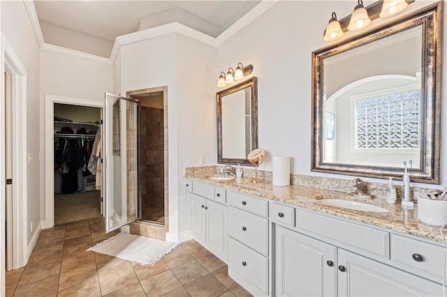 full bathroom with double vanity, a stall shower, a spacious closet, and a sink