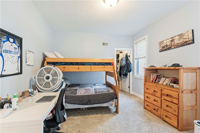 bedroom with baseboards, visible vents, and light colored carpet