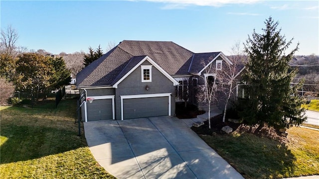 traditional-style home featuring a front yard, driveway, and stucco siding