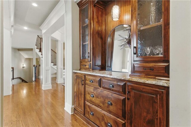 interior space with arched walkways, stairs, recessed lighting, light wood-type flooring, and pendant lighting