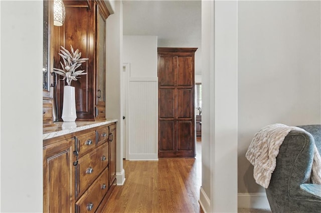 hallway featuring baseboards and light wood-type flooring