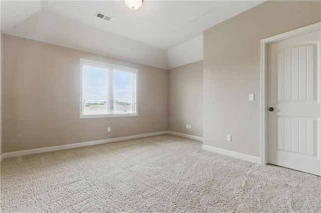 carpeted spare room with baseboards, vaulted ceiling, and visible vents