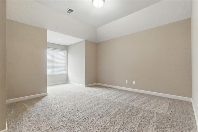 carpeted spare room featuring visible vents and baseboards