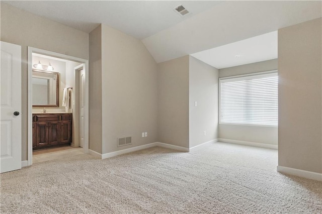 unfurnished bedroom featuring vaulted ceiling, baseboards, carpet flooring, and visible vents