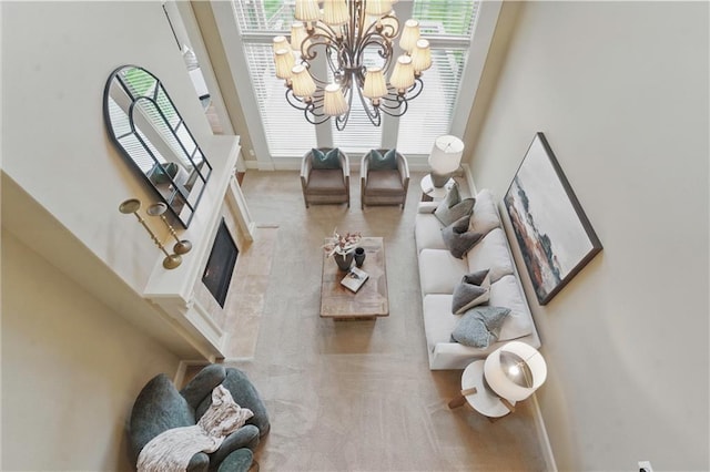 carpeted living area with baseboards, an inviting chandelier, a glass covered fireplace, and a wealth of natural light