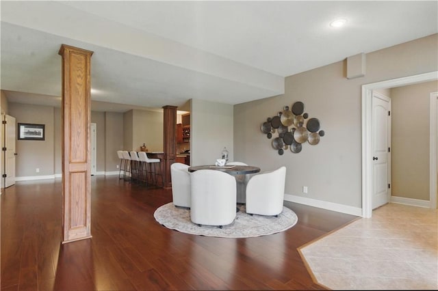 dining area with baseboards and wood finished floors