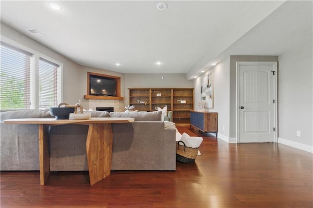 living area featuring visible vents, wood finished floors, a fireplace, baseboards, and recessed lighting