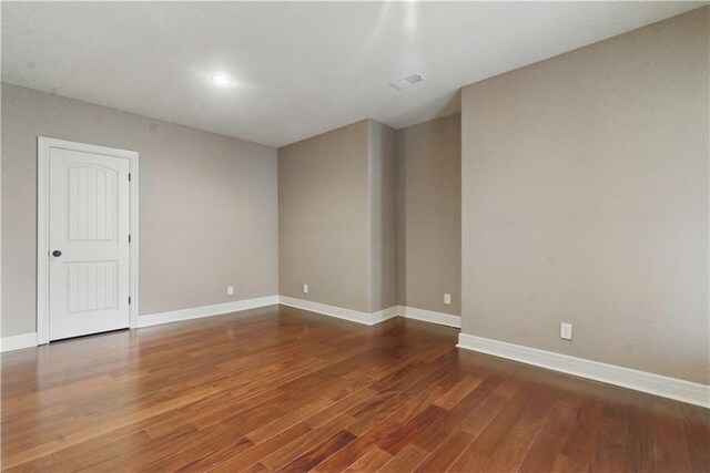 empty room featuring baseboards, recessed lighting, wood finished floors, and visible vents