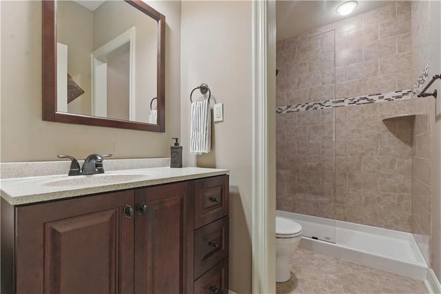 bathroom featuring vanity, tile patterned flooring, toilet, and a shower stall
