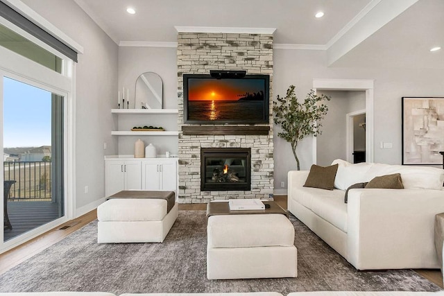 16649 S Tomashaw St, Olathe, KS 66062 - living room featuring crown molding, wood finished floors, a stone fireplace, and built in shelves