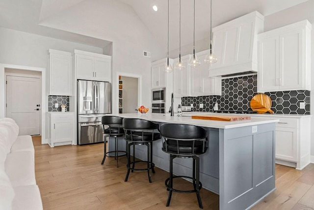 16649 S Tomashaw St, Olathe, KS 66062 - kitchen with a center island with sink, white cabinets, appliances with stainless steel finishes, and tasteful backsplash