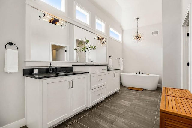 16649 S Tomashaw St, Olathe, KS 66062 - full bathroom with vanity, visible vents, a soaking tub, a high ceiling, and a notable chandelier