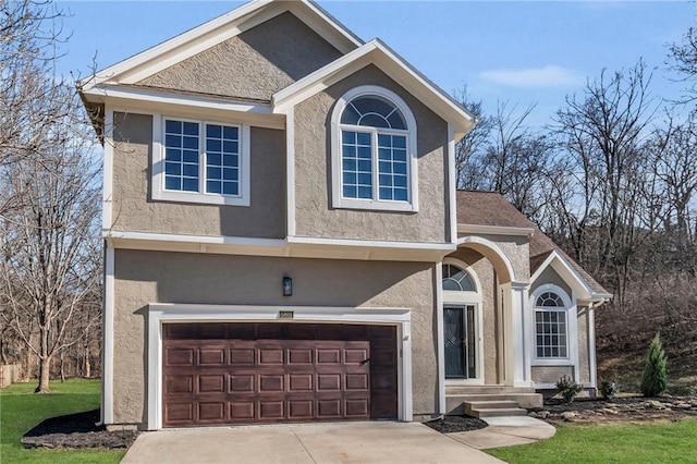 traditional home featuring an attached garage, a front lawn, concrete driveway, and stucco siding