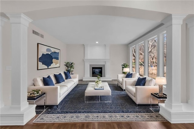 living room with decorative columns and visible vents