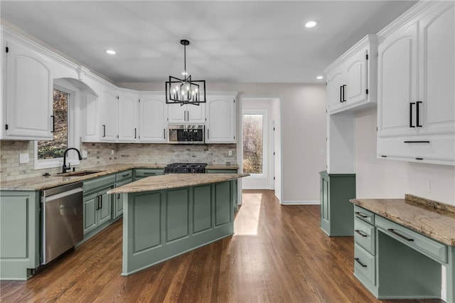 kitchen with appliances with stainless steel finishes, a sink, white cabinetry, and green cabinetry