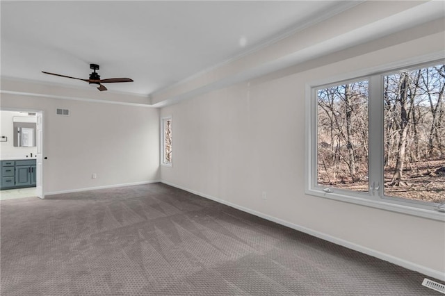 carpeted spare room featuring visible vents, plenty of natural light, and baseboards