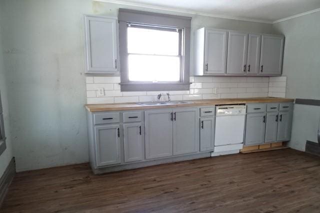 kitchen featuring white dishwasher, a sink, wood counters, and decorative backsplash