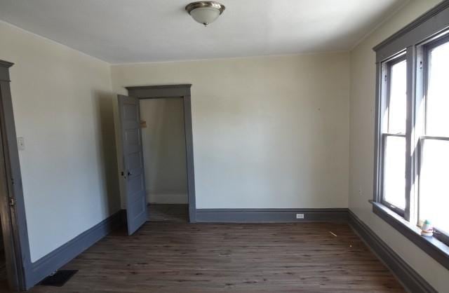 spare room featuring dark wood finished floors and baseboards