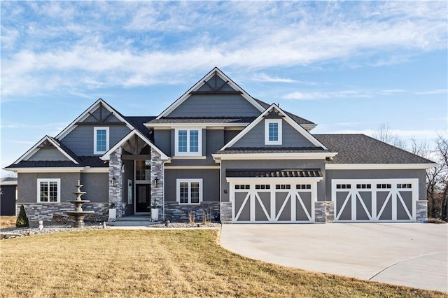 craftsman-style home featuring stone siding, a front yard, concrete driveway, and stucco siding