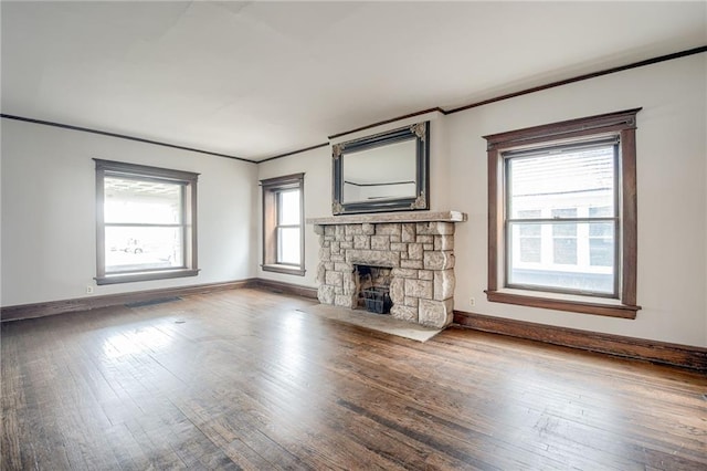 unfurnished living room featuring hardwood / wood-style floors, a fireplace, baseboards, and ornamental molding