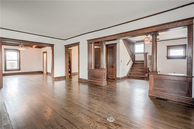 unfurnished living room with ceiling fan, stairway, baseboards, and wood finished floors