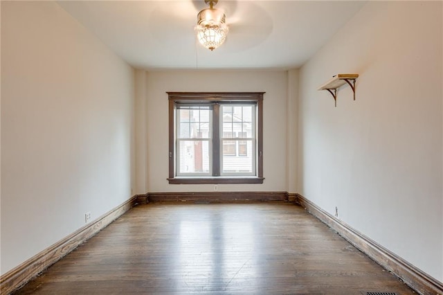 spare room featuring a ceiling fan, baseboards, and wood finished floors