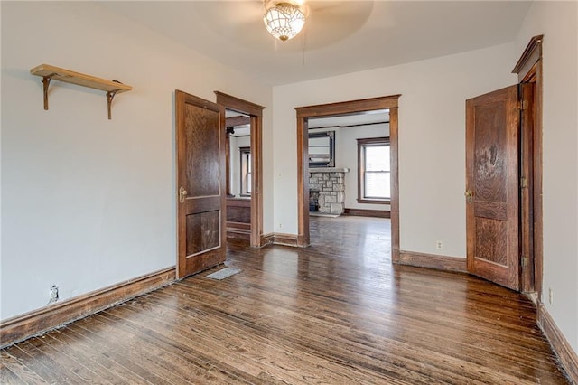 unfurnished room with a ceiling fan, wood finished floors, and baseboards