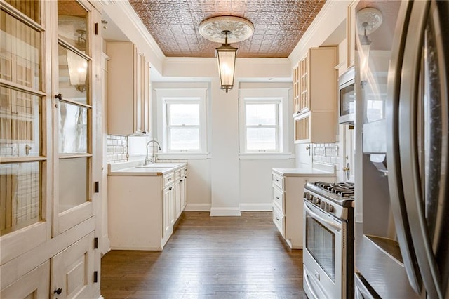 kitchen with ornamental molding, a sink, an ornate ceiling, stainless steel appliances, and decorative backsplash