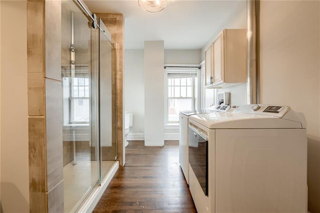 washroom with washer and dryer, baseboards, cabinet space, and dark wood finished floors