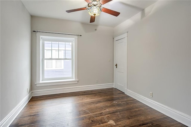 empty room with baseboards, dark wood-type flooring, and ceiling fan